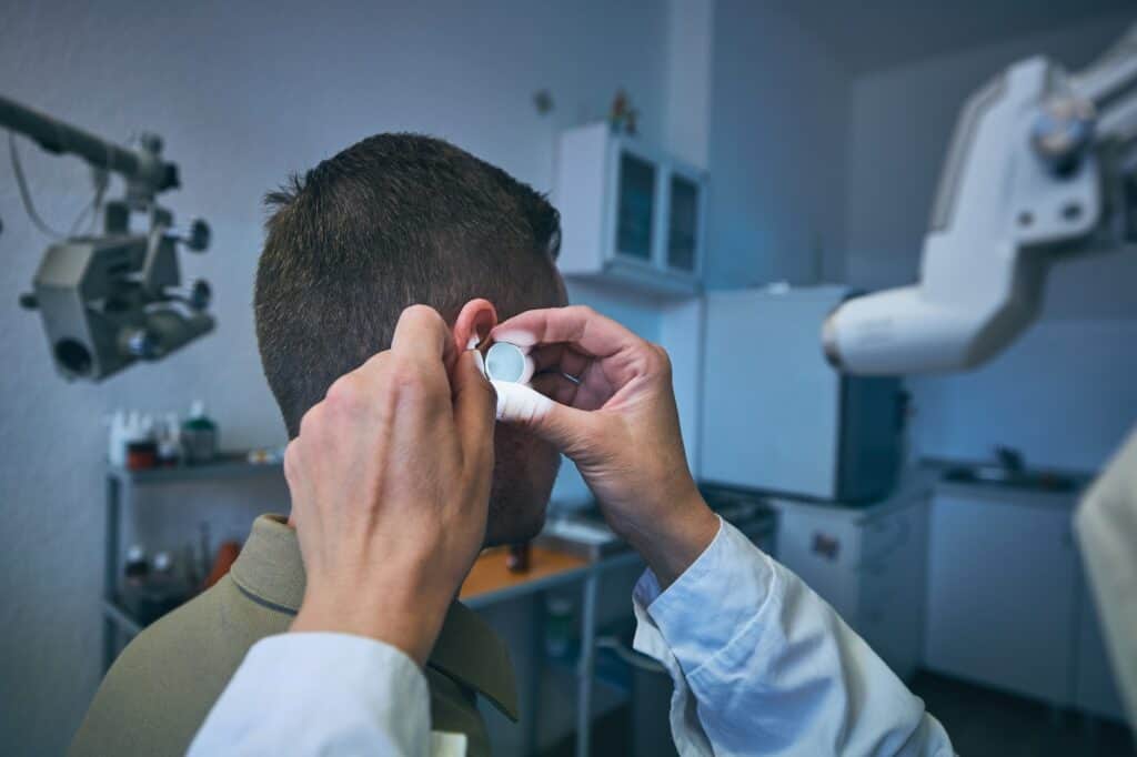 Doctor doing ear examination of young patient